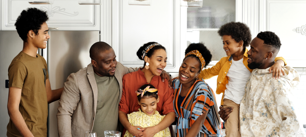 A family stands around the kitchen lovingly.