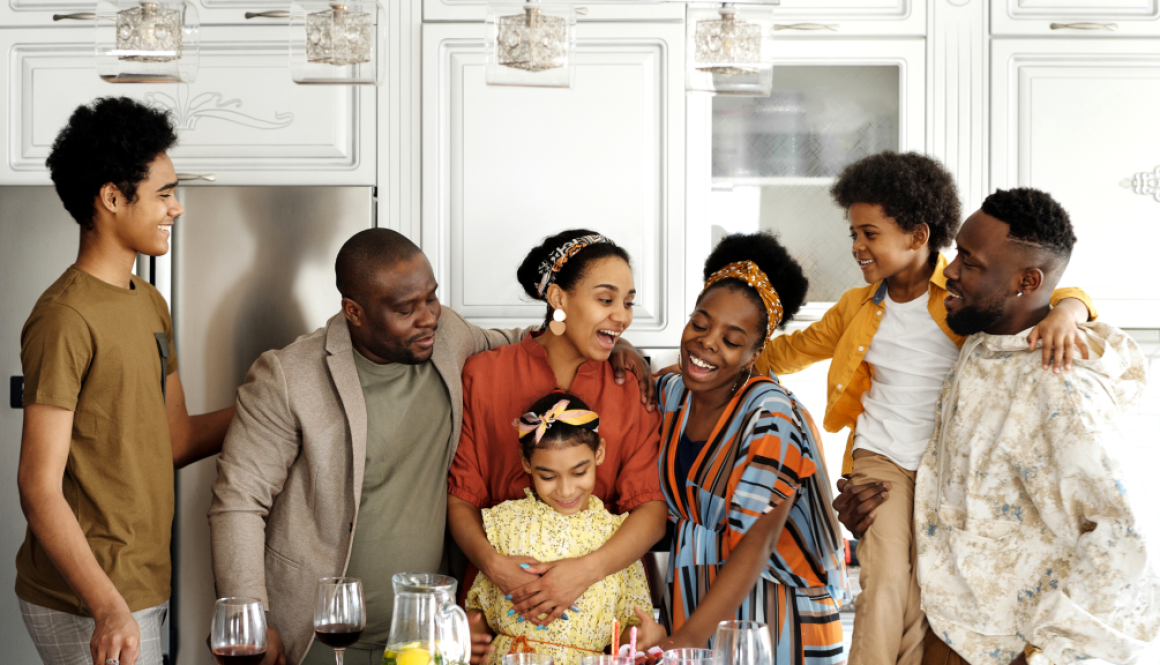 A family stands around the kitchen lovingly.