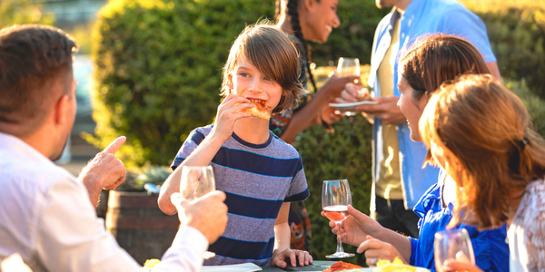 Family and friends eat together outside.